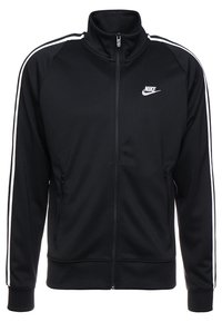 Chaqueta con cremallera negra de Nike, con rayas blancas a lo largo de las mangas y logo blanco de Nike en el lado izquierdo del pecho, que presenta un alto cuello y bolsillos laterales con cremallera.