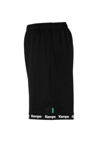 Zwarte sportshorts gemaakt van lichtgewicht stof. Elastische tailleband met het witte "Kempa"-logo op de zoom. Beschikt over een groene label.
