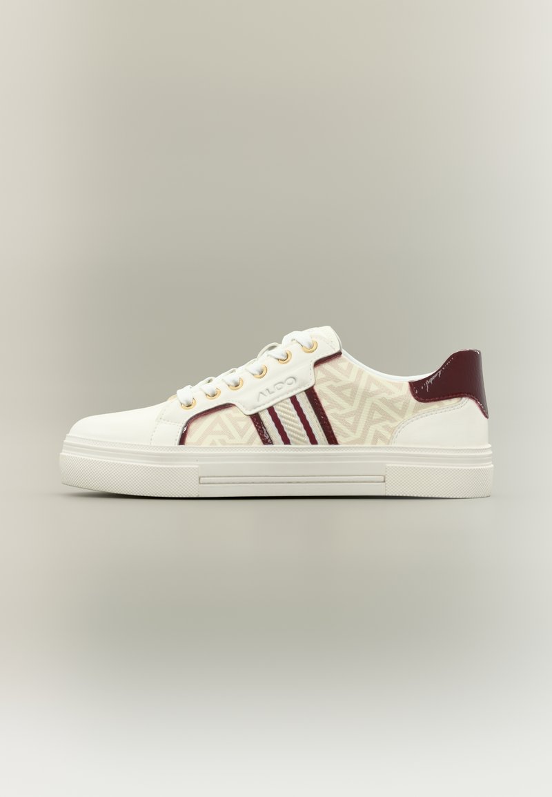 Weißer Sneaker mit Obermaterial aus geometrisch gemustertem Textil, burgunderfarbenen Akzenten, goldenen Ösen und profilierter Gummisohle. Seitenansicht.