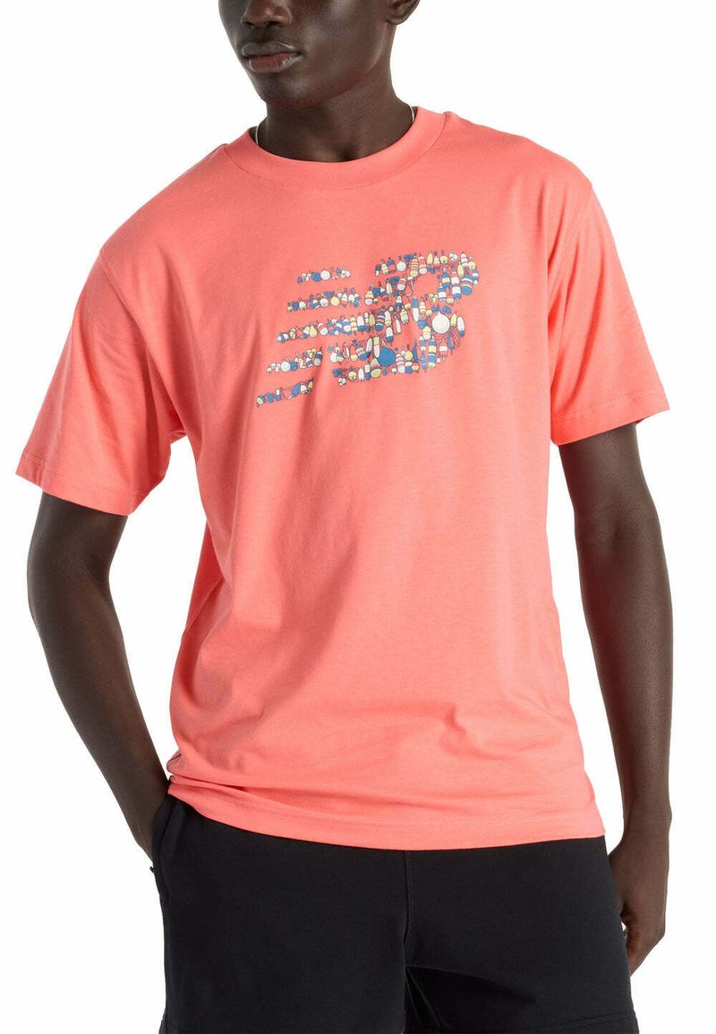Camiseta de algodón color coral con un logo gráfico "N" multicolor en el frente. El diseño incluye diversas formas y patrones.