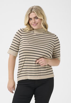 Beige pletený top s černými horizontálními pruhy, krátké rukávy a designem s falešným límcem. Nosené s černými kalhotami a náramkem.
