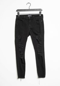 Černé džíny skinny s opotřebovaným vzhledem, trhanými detaily, a roztrženými lemami, klasický design s pěti kapsami. Vyrobeny z denimové tkaniny, s knoflíkovým zapínáním.