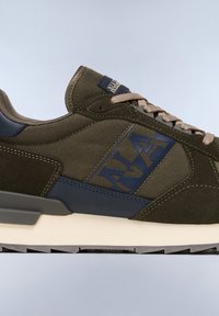 Olive green sneaker with textured fabric and smooth suede accents, featuring a navy logo, beige laces, and a white midsole.