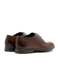 Pantofi de dress din piele maro cu finisaj neted, vârf rotund și design clasic cu șireturi. Talpă din cauciuc pentru durabilitate și aderență.