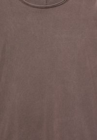 Mauve Baumwoll-T-Shirt mit rundem Ausschnitt, weicher Textur und schlichtem Design, das dezente Nähte am Ausschnitt aufweist.