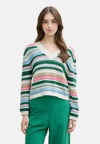 Gestreepte v-hals trui in groen, roze, blauw en beige. Heeft een open gebreid ontwerp en geribde manchetten, gecombineerd met groene broeken.