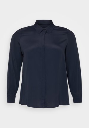 Bluză lungă cu mâneci, de culoare bleumarin, dintr-un material neted, cu guler ascuțit și închidere frontala cu nasturi, având o croială lejeră.