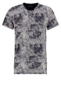 Camiseta de manga corta en blanco y negro con un patrón salpicado, escote redondo y diseño abstracto texturizado.