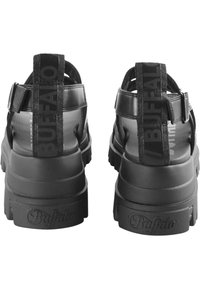 Black sandals with a chunky sole. Made of synthetic material, featuring adjustable straps and "Buffalo" branding on the back.