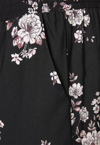 Svart tyg med ett blommönster som har rosa och vita blommor, slät textur, rynkad midja och vertikala veck.