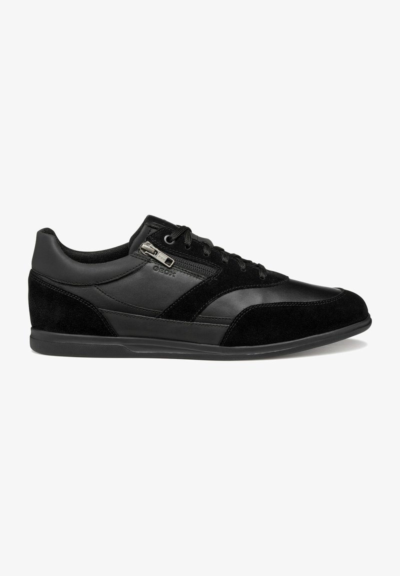Baskets basses noires avec des panneaux en cuir et en suède, des lacets noirs, une fermeture éclair latérale et une semelle en caoutchouc plate.