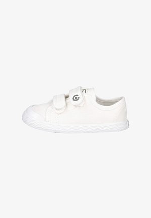 Zapatilla blanca para niños con dos tiras de Velcro y suela de goma con patrón ondulado, vista lateral sobre fondo blanco.