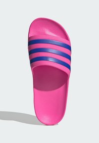 Pink slide sandal with a textured surface, featuring three horizontal blue stripes across the strap. Flat footbed, casual design.