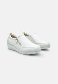Scarpe bianche slip-on in pelle con finitura texturizzata, dotate di una zip laterale e suola in gomma chiara.