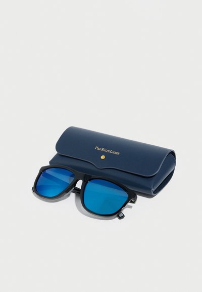 Γυαλιά ηλίου με μαύρους πλαστικούς σκελετούς και μπλε καθρέφτη φακούς δίπλα σε σκούρα μπλε σκληρή θήκη με χρυσό λογότυπο και κούμπωμα ασφαλείας.