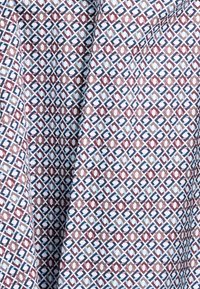 Geweven stof met een geometrisch ontwerp in blauw, kastanjebruin en crème. De textuur is glad met een glanzende afwerking.