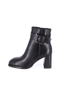 Stivale alla caviglia in pelle nera con punta quadrata, tacco a blocco di altezza media e una larga fascia con dettaglio di fibbia metallica.