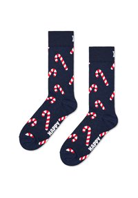 Chaussettes bleu marine avec des motifs de cannes en bonbon blanches et rouges, une bordure côtelée et le texte "HAPPY" sous la semelle. Texture douce en tricot.