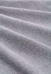 Grauer Stoff mit glatter Textur, der ein feines Gewebe und einen subtilen Glanz aufweist. Das Material ist drapiert und präsentiert sanfte Falten und Konturen.