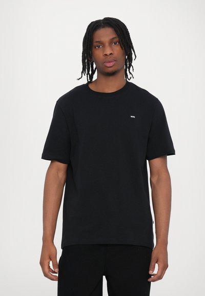 Tricou din bumbac negru, cu mâneci scurte și decolteu rotund. Prezintă un mic logo alb pe piept și are o croială lejeră, asortat cu pantaloni negri.