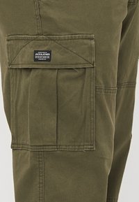 Olijfgroene cargo pants van katoen, met een grote klepzak met label, gestikt detail en een rechte pasvorm.