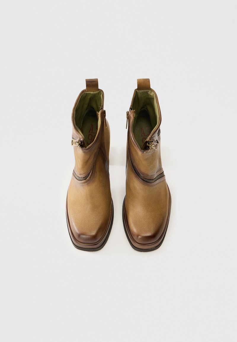 Bottines en cuir marron avec une finition lisse, fermetures éclair latérales et un bout légèrement arrondi. Doublure intérieure vert chaud et semelle marron contrastante.
