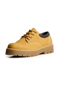 Pantofi împletiți din suede galben, cu accente din piele maro, vârf rotunjit și talpă groasă din cauciuc cu un model texturat.