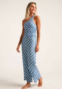 Vestido maxi azul de un solo hombro con patrón floral blanco; tela suave y elástica; abertura lateral; cuerpo ajustado y corte relajado desde la cintura hacia abajo.