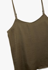 Harmaanvihreä, kevyt toppi, jossa on ohuet säädettävät olkaimet, rento istuvuus ja hieman teksturoitu pinta. Ei merkittäviä kuvioita.