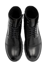 Czarne skórzane botki za kostkę o gładkiej teksturze, sznurowanym wzornictwie, wyściółce na kołnierzu oraz gumowej podeszwie z białymi przeszyciami.