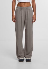 Grijze, wijde broekspijpen gemaakt van lichte stof met een elastische tailleband en trekkoord, met een soepele textuur en subtiele glans.