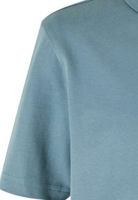 Košile s krátkým rukávem z jemné modré bavlny. Má hladký povrch, švy na lemování a klasický design límce.