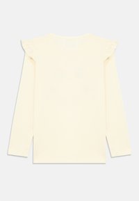 Camisa de manga larga en algodón amarillo pálido con detalles fruncidos en los hombros. Diseño trasero sencillo y sin adornos, dobladillo recto.