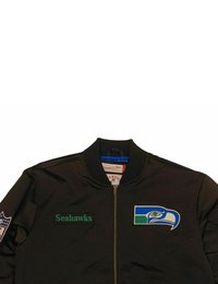 Schwarze Bomberjacke mit grünem „Seahawks“-Text, ausgestattet mit einem gestickten Seahawks-Logo in Blau und Grün auf der Brust und dem Ärmel.