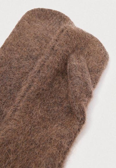 Braune Filz-Handschuhe mit einer kuscheligen Textur, die an der Oberseite eine geschwungene Form und eine Naht in der Mitte aufweisen, entworfen für Wärme und Komfort.