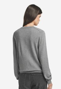 Grau gestrickter Pullover aus weichem Stoff mit Rundhalsausschnitt, langen Ärmeln und lockerer Passform; strukturierte Oberfläche mit gerippten Bündchen und Saum.