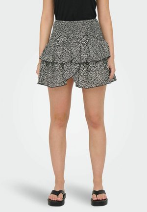 Gonna a strati a pois in bianco e nero con un design arricciato, dotata di vita elastica e di un orlo che arriva sopra il ginocchio.