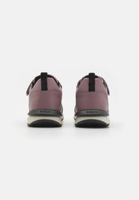 Chaussures GEOX avec un dessus en cuir violet, des accents noirs et un dos texturé. Présente une languette et une semelle blanche avec des détails noirs.