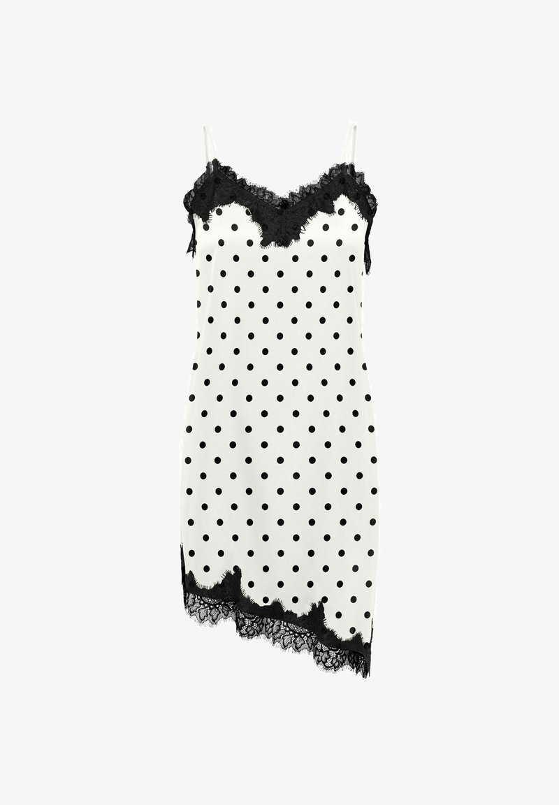 Robe nuisette blanche à pois noirs, avec un bord en dentelle noire au niveau de l'encolure et un ourlet asymétrique, ainsi que de fines bretelles blanches spaghetti.