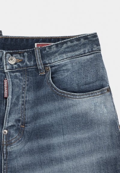 Μέρος μέσης μπλε τζιν denim με μεταλλικό κουμπί, θηλιά ζώνης, μπροστινή τσέπη και κόκκινη υφασμάτινη ετικέτα που δείχνει "DSQUARED2".
