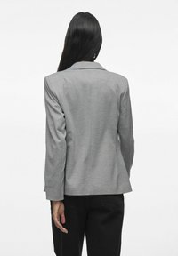Blazer gris au design structuré, avec revers et manches longues. Fabriqué à partir d'un tissu lisse, présentant une coupe ajustée et une fente arrière.