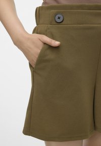 Oliven grønne shorts med en glat tekstur, sidelommer og en sort knapdetalje ved taljen. Minimalistisk design uden mønstre.