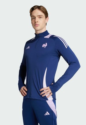 Navy athletic long-sleeve shirt with a quarter-zip, pink accents, and rooster logo. Made of smooth fabric with a fitted design.