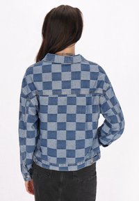 Jeansjacka med ett bl�ått och ljusblått rutig mönster, med krage, långa ärmar och knapppdetaljer. Bakvy visas.