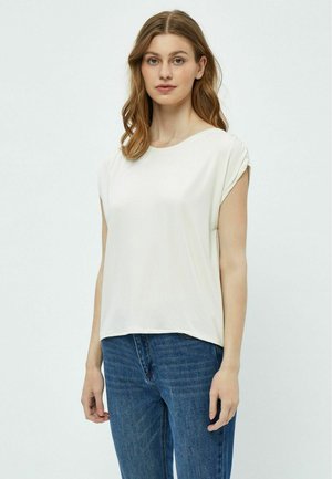 Maglietta corta color beige chiaro con una vestibilità comoda, caratterizzata da un collo rotondo e una texture morbida. Abbinata a jeans in denim blu.