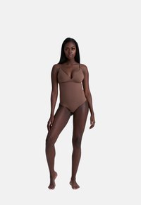 Costume da bagno intero marrone con spalline sottili, texture liscia, coppe sagomate e silhouette aderente, progettato per un aspetto snello.