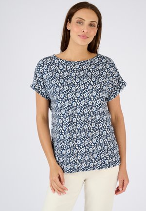 Navy blauwe bloemenblouse met korte opgerolde mouwen, met een wit blad- en bloemenpatroon, gemaakt van lichtgewicht stof, ronde halslijn.
