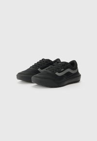 Black sneakers featuring a mesh upper, flat laces, a textured rubber sole, and a sleek design with a subtle logo accent.