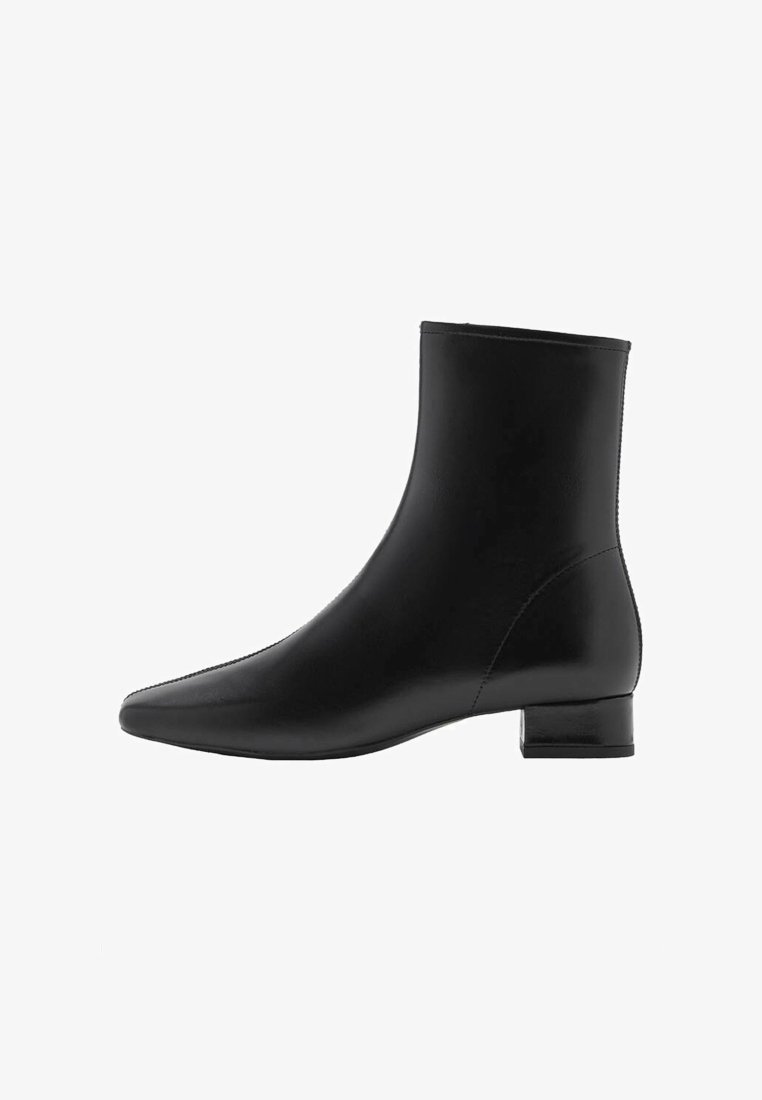 Bottine en cuir noir avec un petit talon carré et un bout pointu, présentée de profil sur un fond blanc.