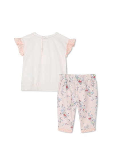 Lichtroze top met korte mouwen en bloemenaccenten op de gerimpelde mouwen, gecombineerd met roze broek met bloemenprint en een elastische tailleband.